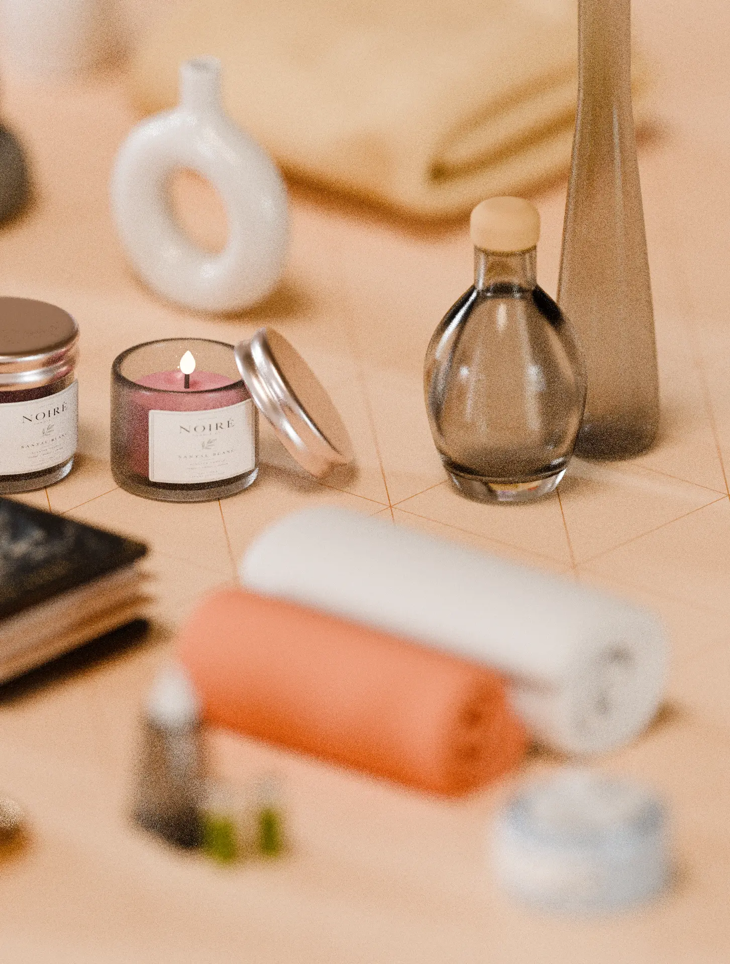 Sandalwood scented candles, glass bottles and rolled peach and white towels
